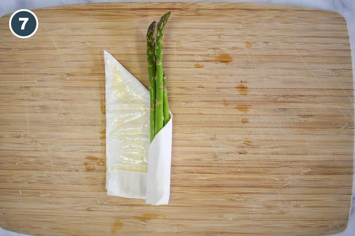Rolling the phyllo tightly around the asparagus spears.
