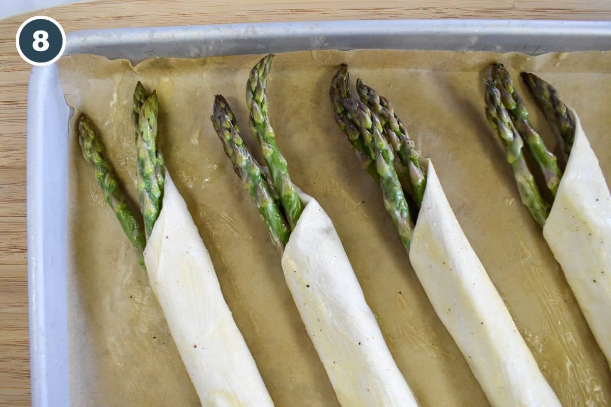 Placing the finished asparagus rolls seam-side down on a parchment-lined baking sheet.