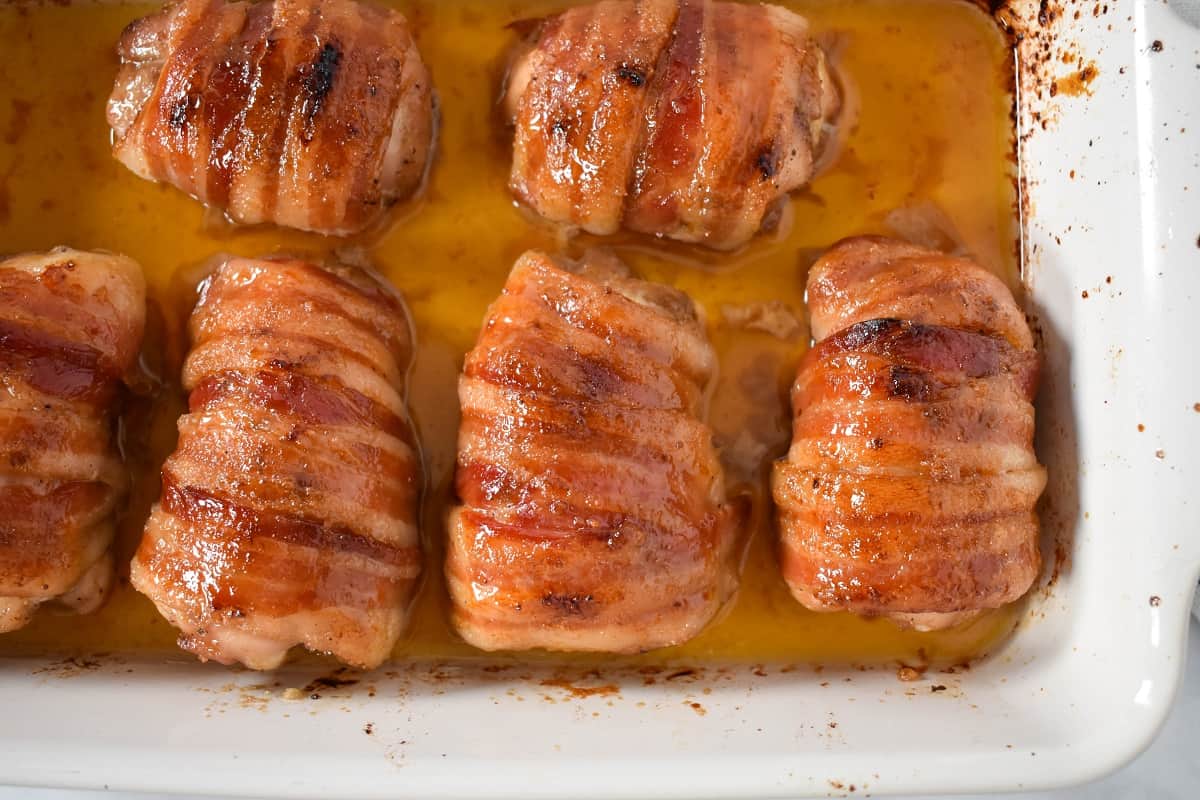 An image of the baked chicken thighs still in the white casserole dish.