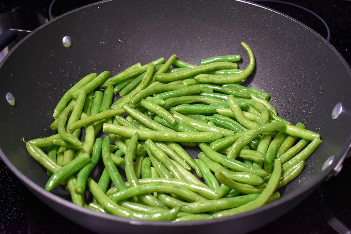 Green beans in a large, black skillet.