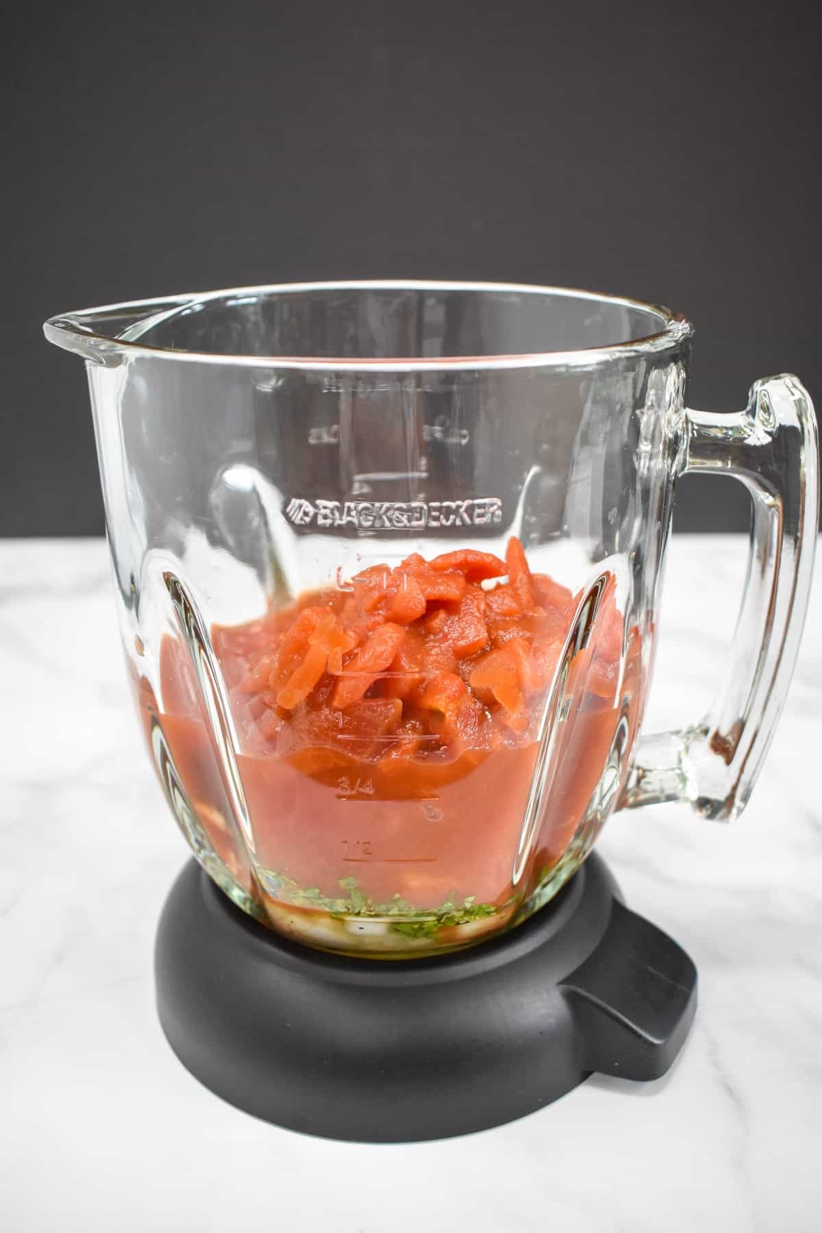 The ingredients added to a blender and set on a white table.