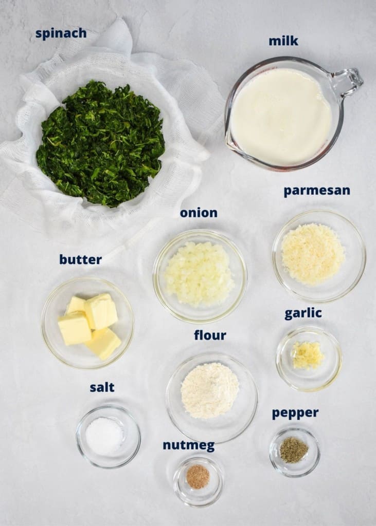 The ingredients for the side dish arranged in glass bowls on a white table. Each one has a label on top with the name of the item.