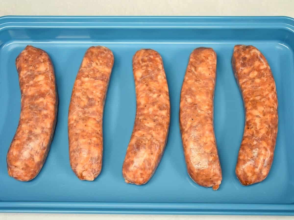 Five Italian sausage links on a light blue pan.