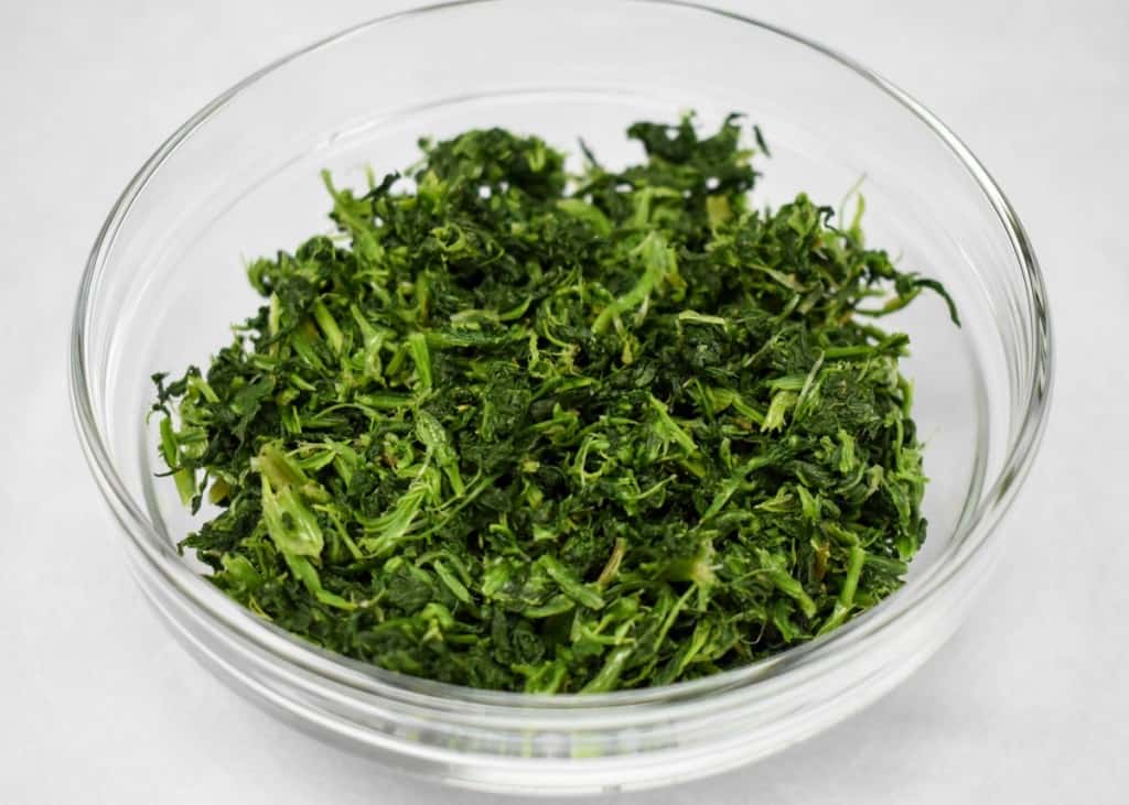 An image of thawed, frozen spinach in a glass bowl.