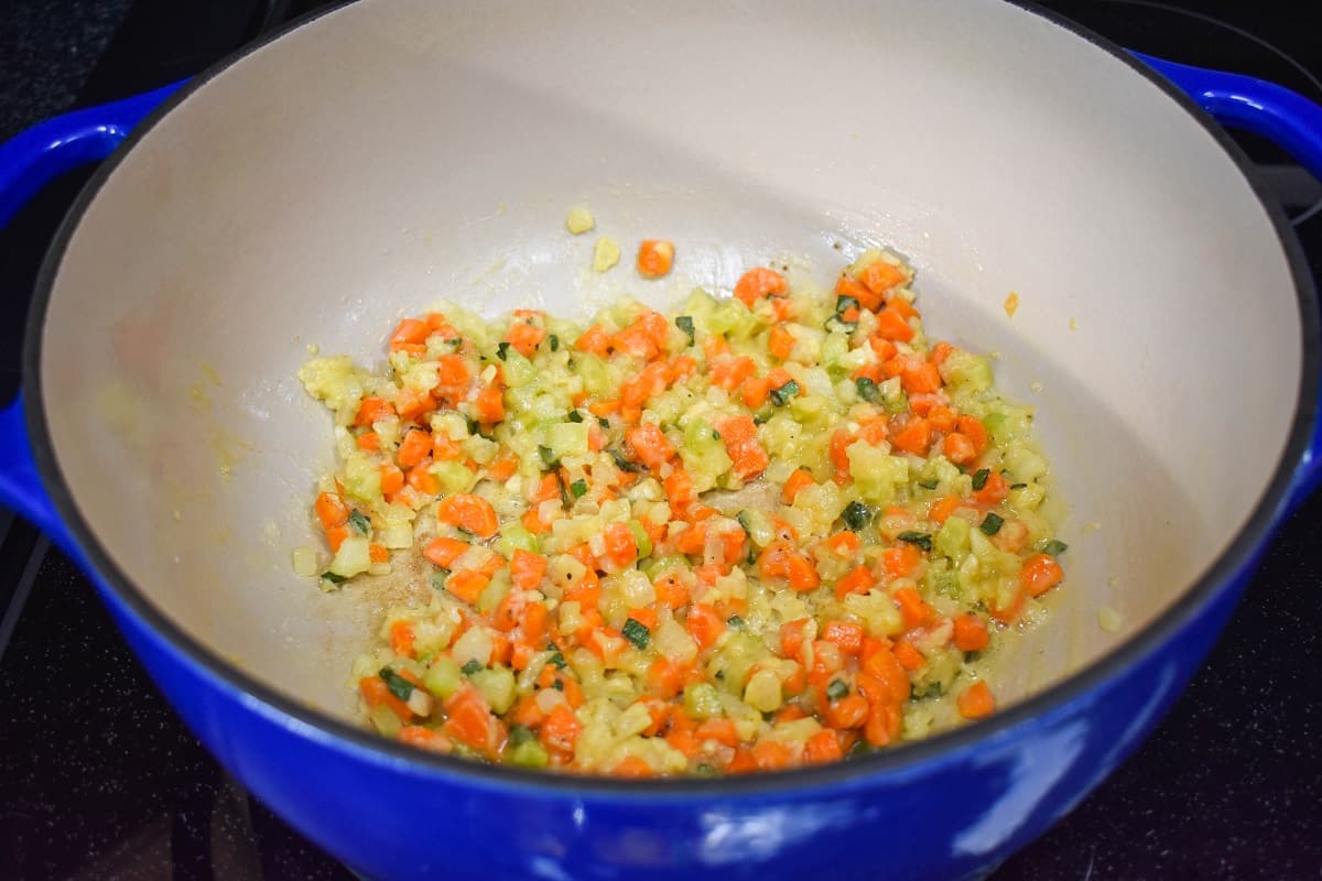 The sautéed vegetables in a large blue and white pot.