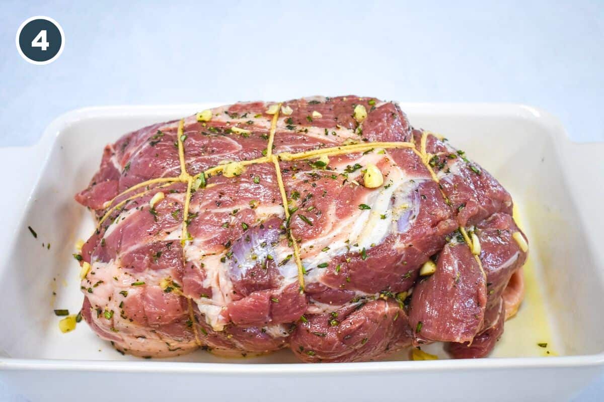 Pork shoulder tied with kitchen twine, seasoned and ready for marinating.