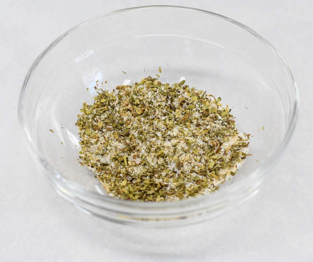 An image of the seasoning mix in a glass bowl set on a white table.