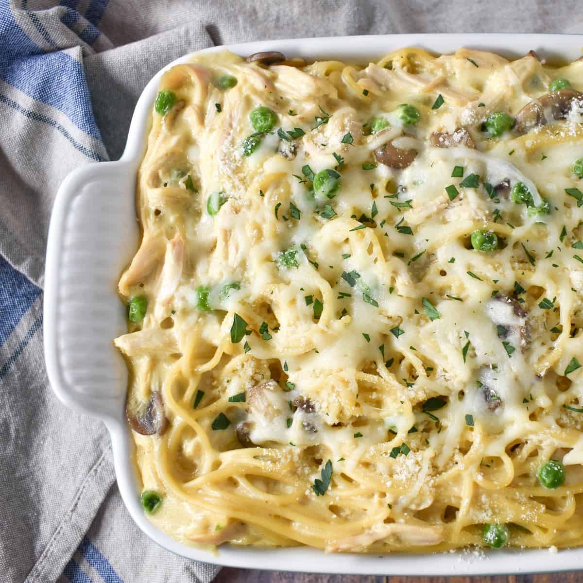 The baked chicken tetrazzini in a white casserole dish.