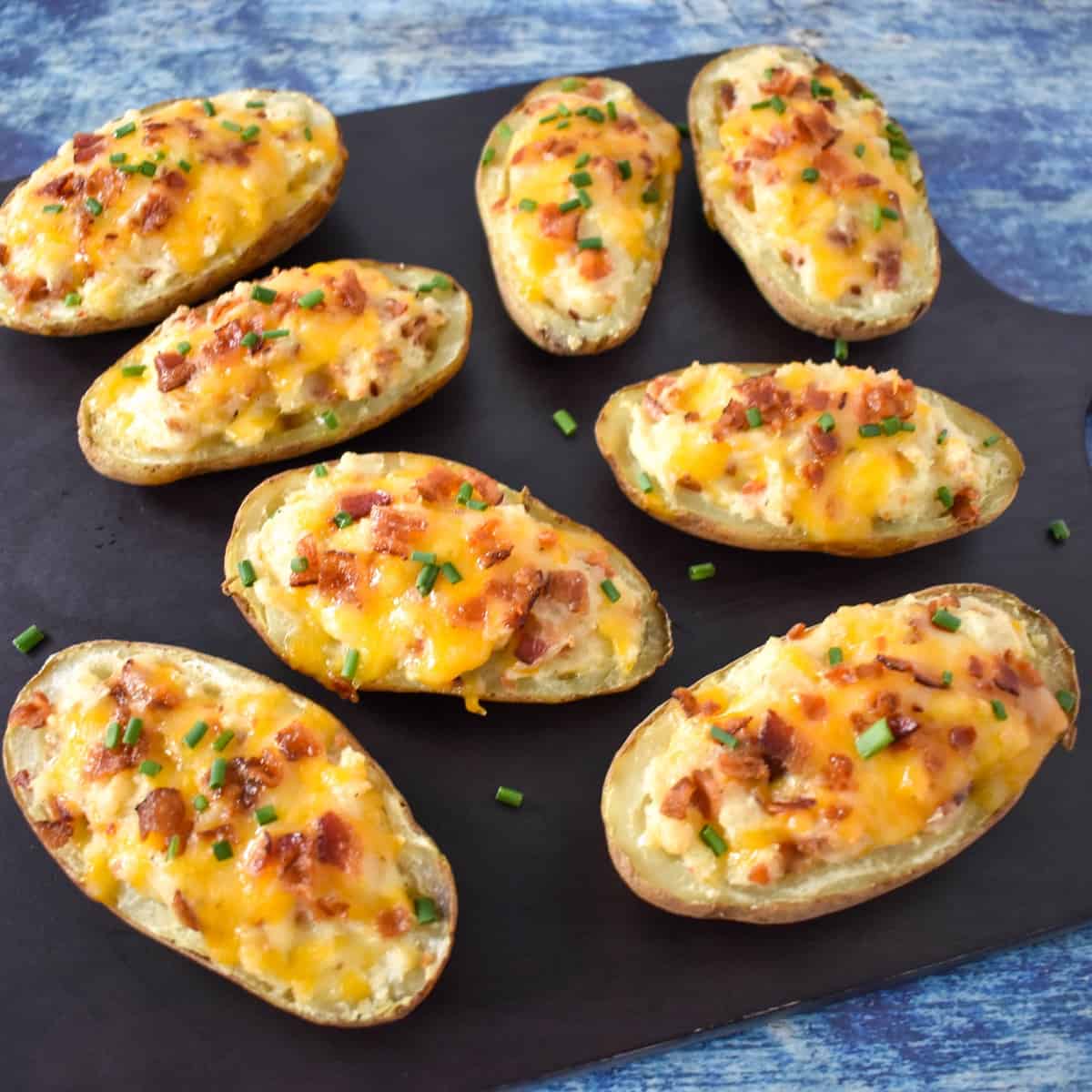 The twice baked potatoes arranged on a black cutting board.