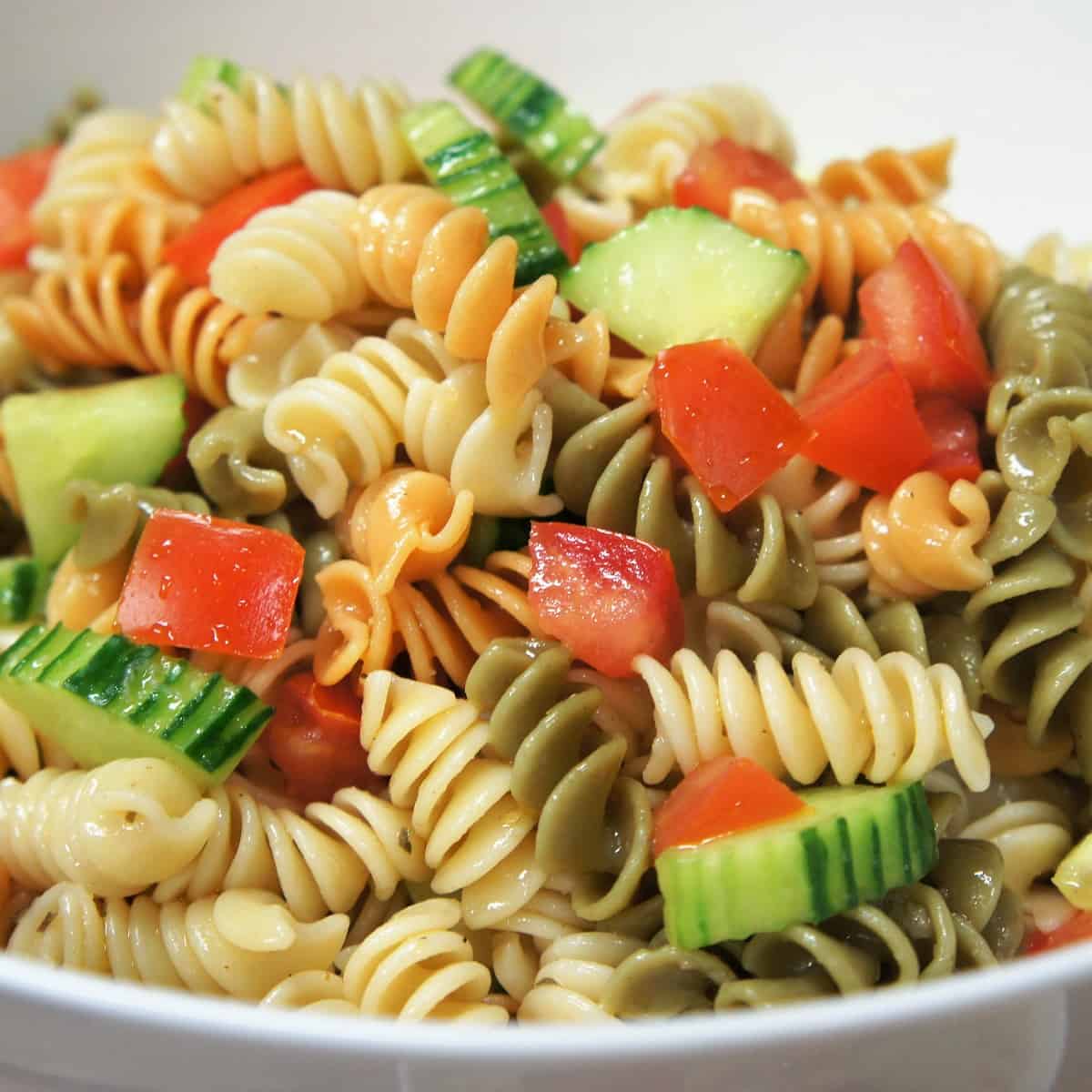 A close up image of the garden pasta salad in a white bowl.