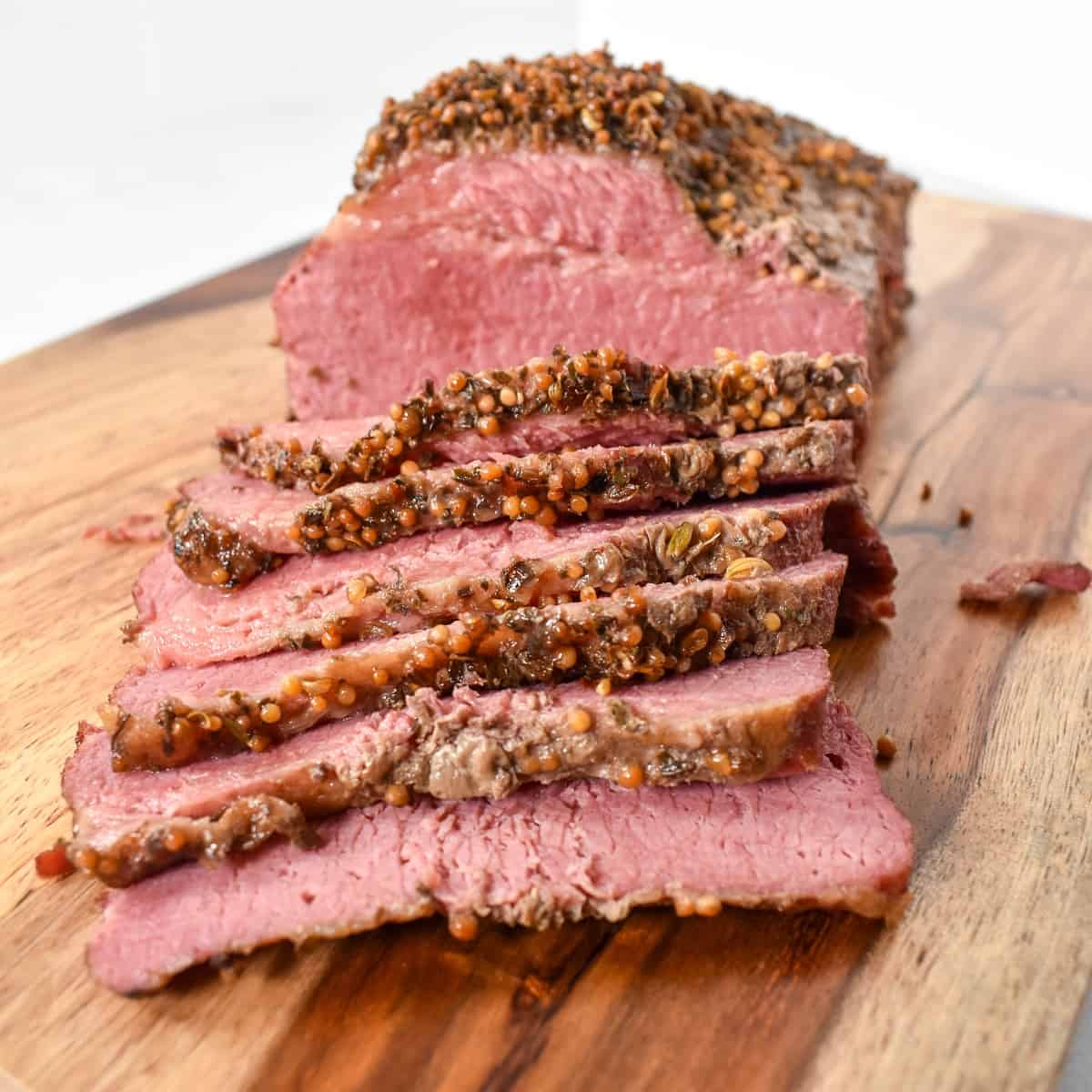 A close-up image of the sliced beef on a wood cutting board.