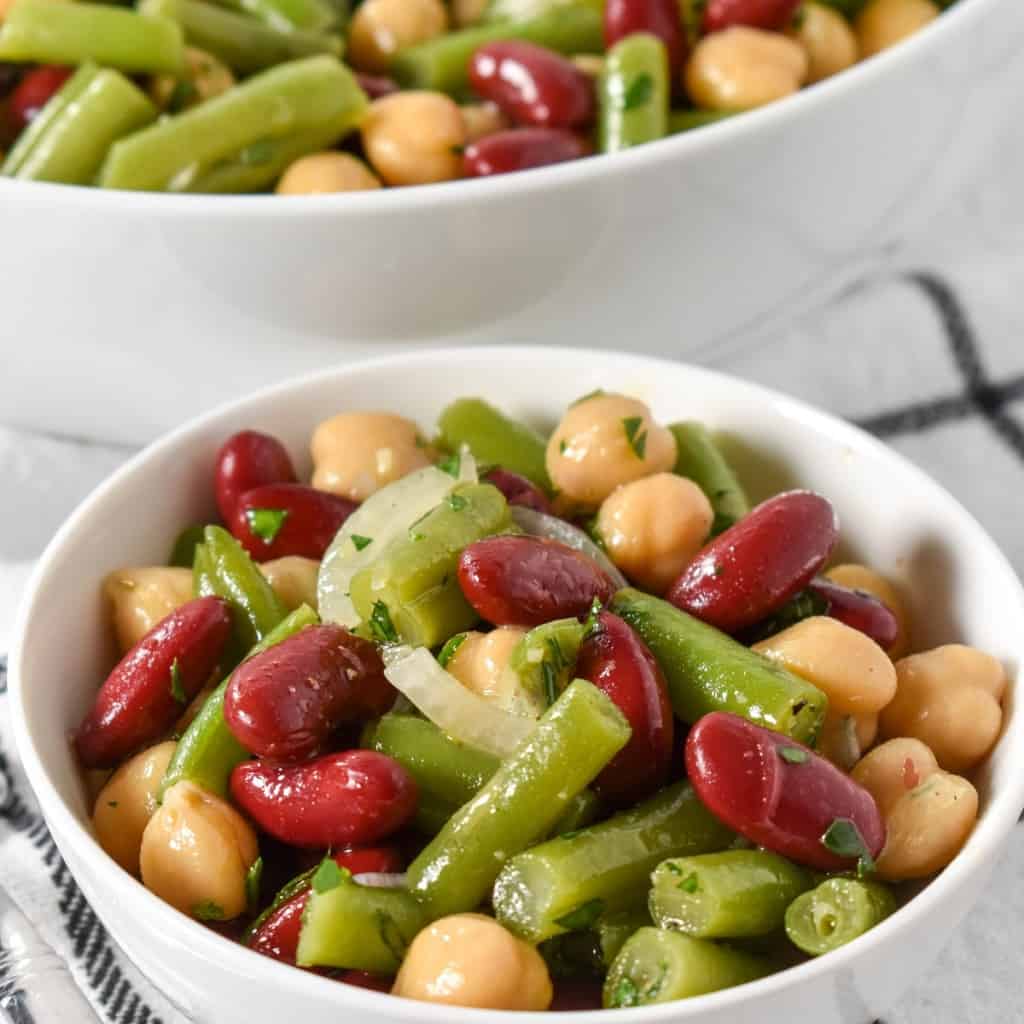 The three bean salad in a white bowl.