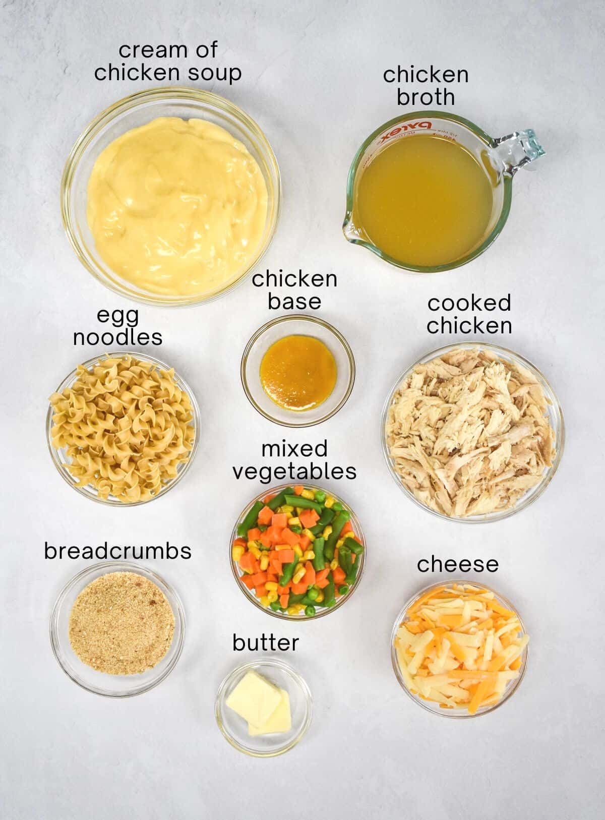 The ingredients for the dish arranged in glass bowls on a white table.