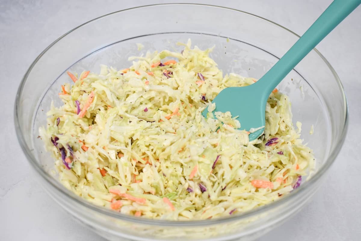 An image of the coleslaw in a large, glass bowl.