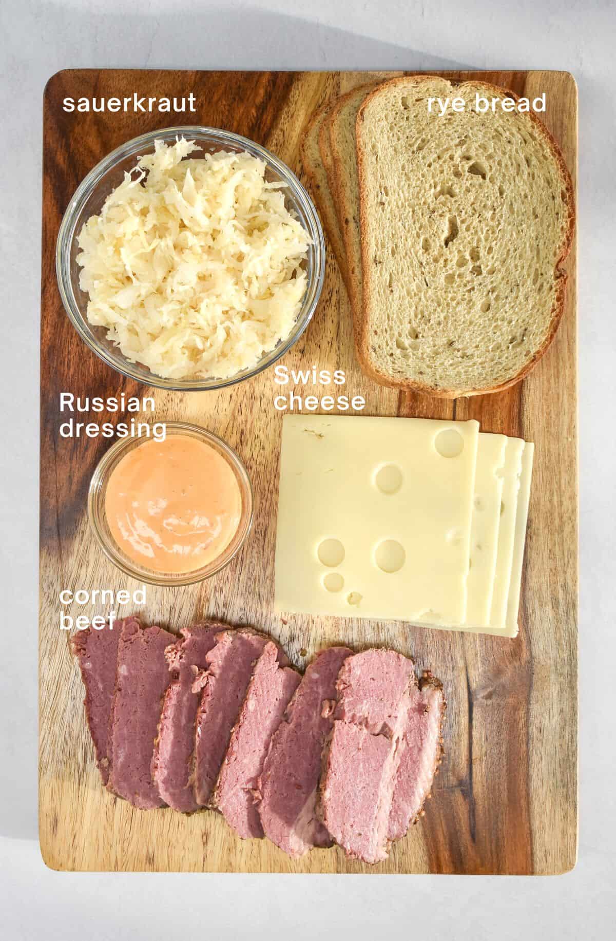 The ingredients for the sandwich arranged on a wood cutting board.