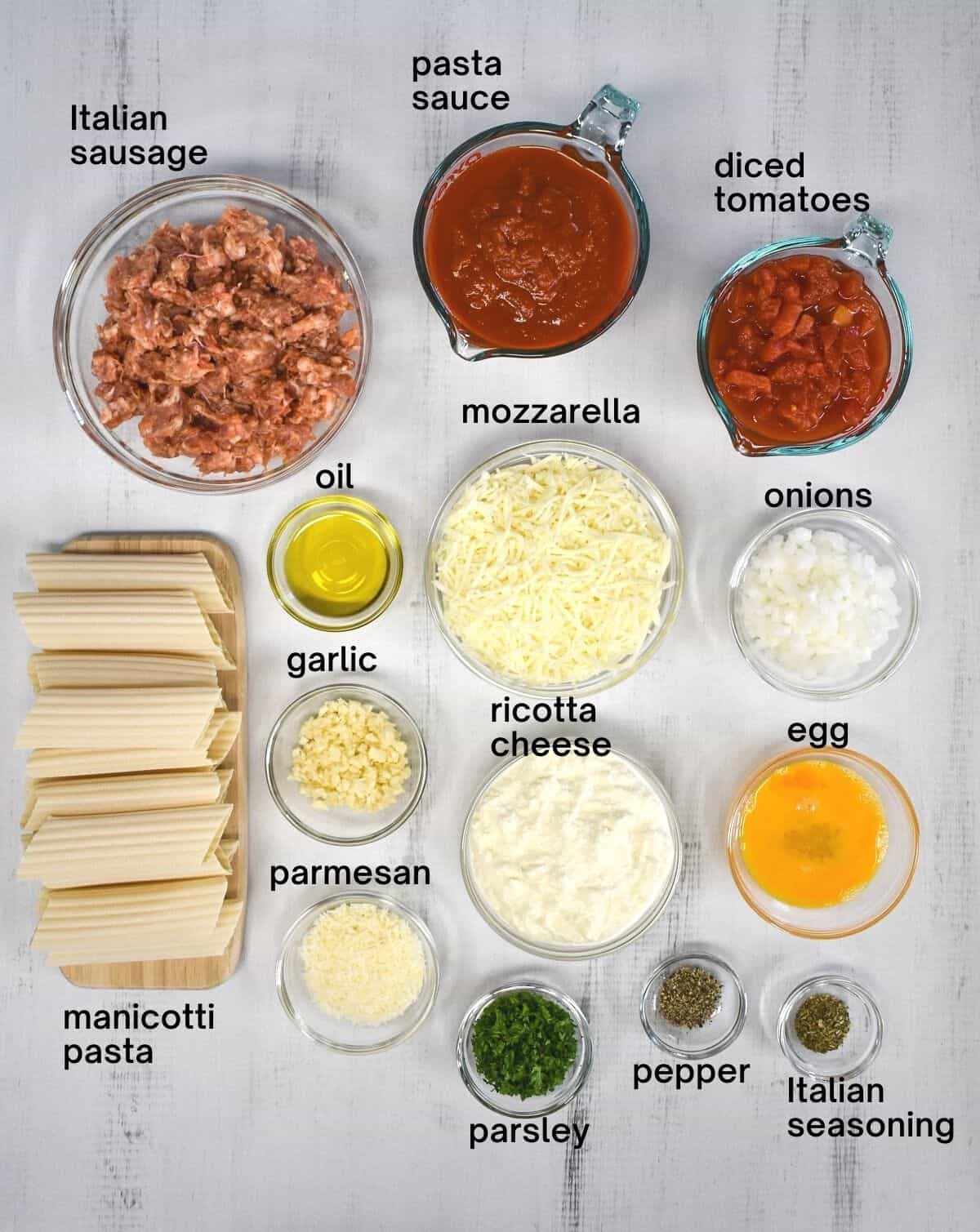 The ingredients for the dish arranged in glass bowls and set on a white table. Each ingredient is labeled.