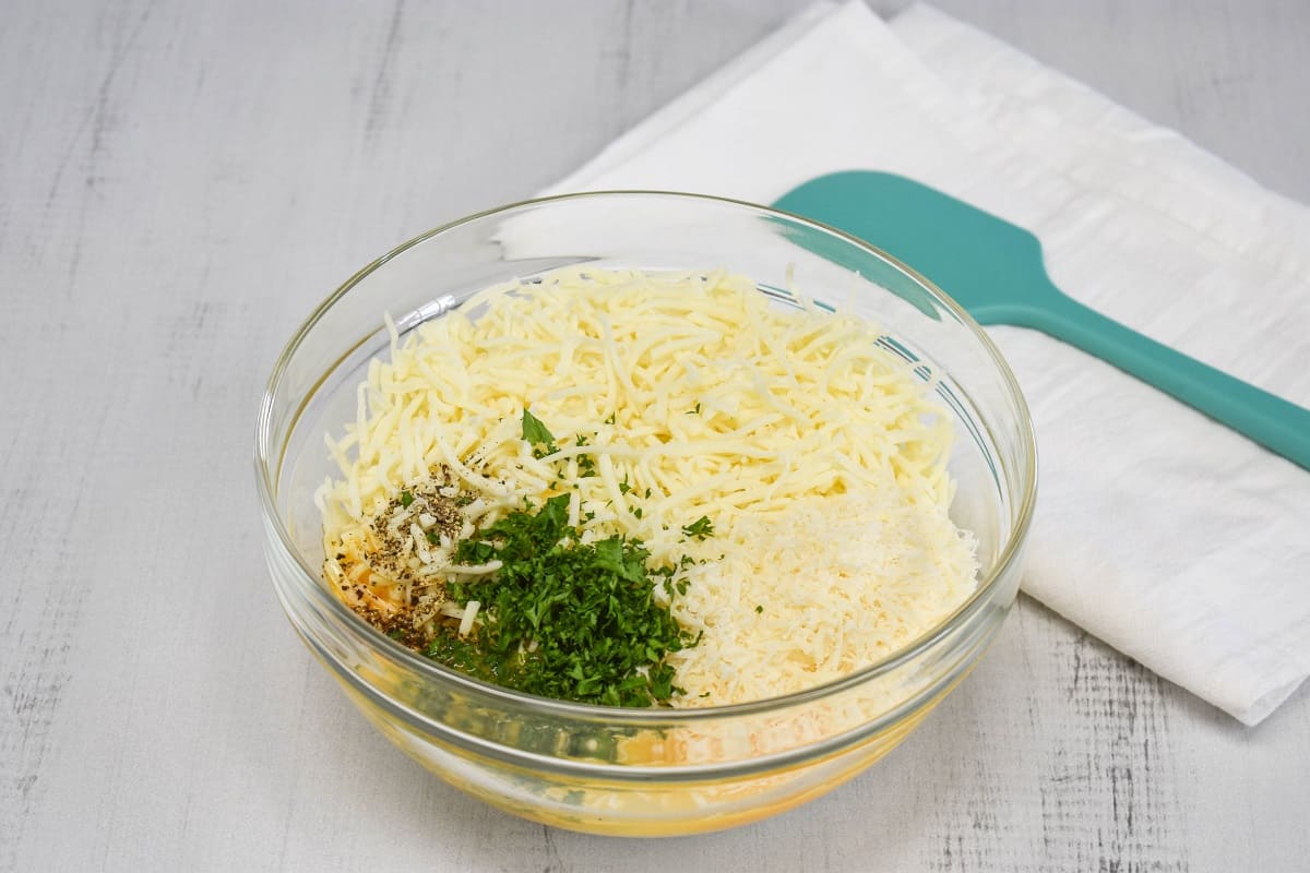 An image of the ingredients for the cheese mixture in a large, glass bowl.
