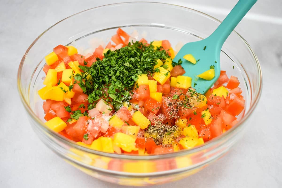 All the prepped ingredients in a large bowl with an aqua colored silicone spatula.