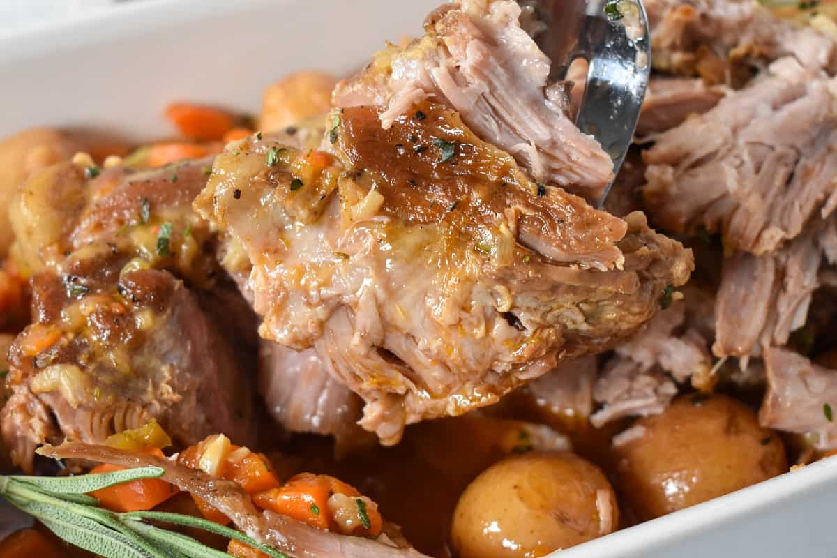 A chunk of the meat held up over the baking dish.