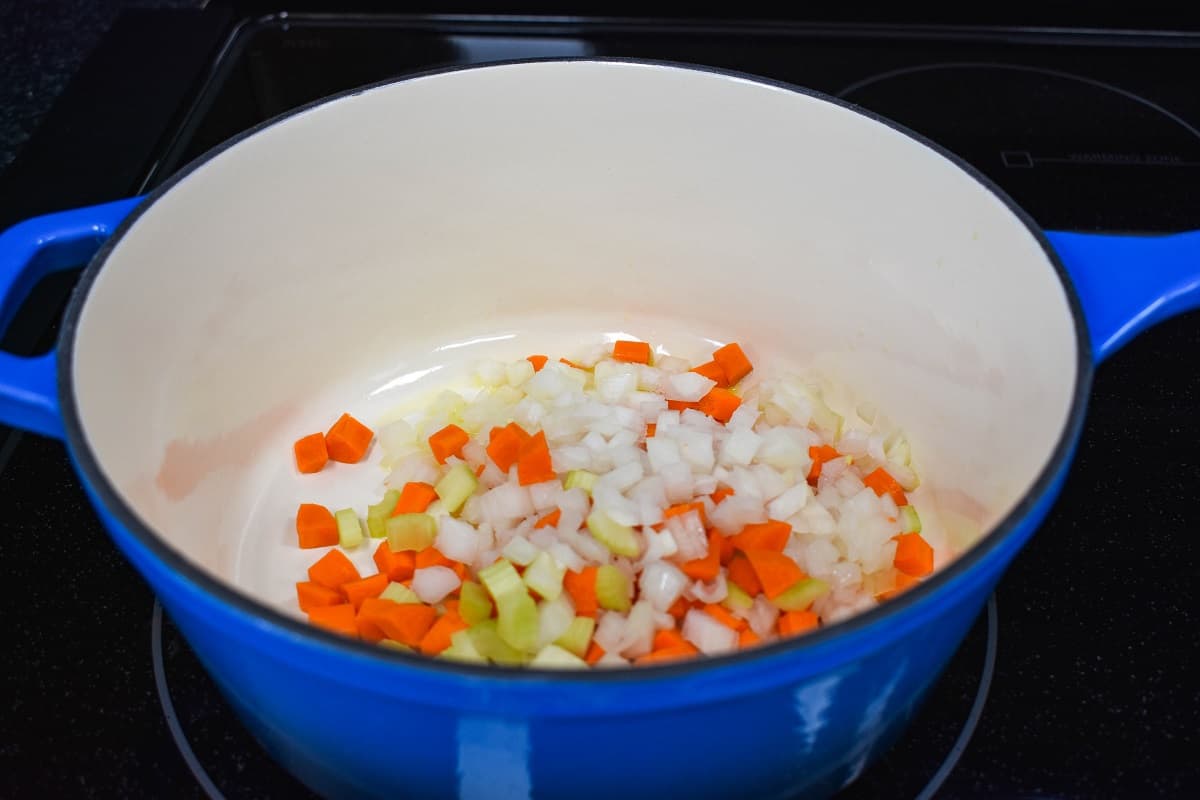 Onions, carrots, and celery cooking in a large pot.