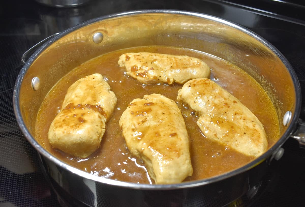 The four pieces of chicken added back to the skillet with the onion sauce in it.