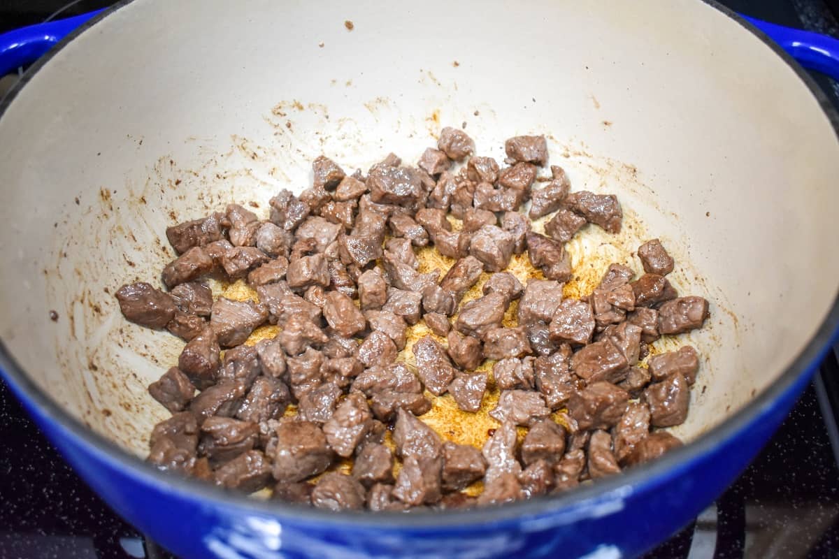 Small beef pieces browning in a large pot.