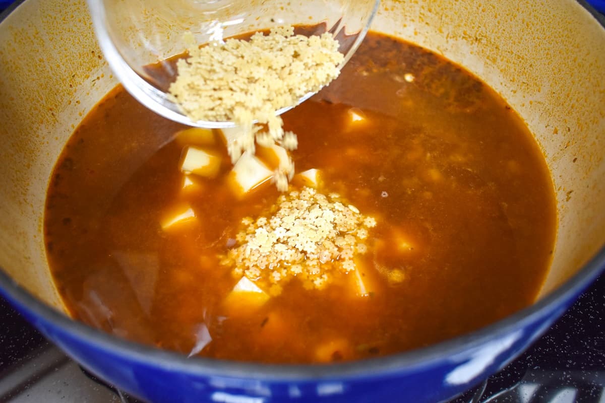 Small pasta being added to the soup.