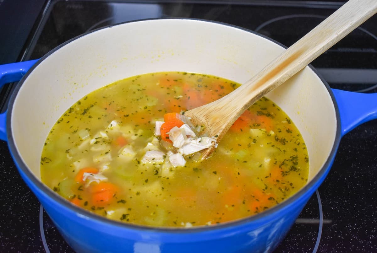 Diced chicken added to the ingredients in the pot.