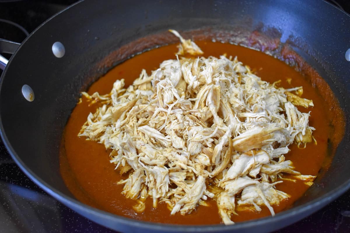 Shredded chicken added to the skillet with the tomato sauce.