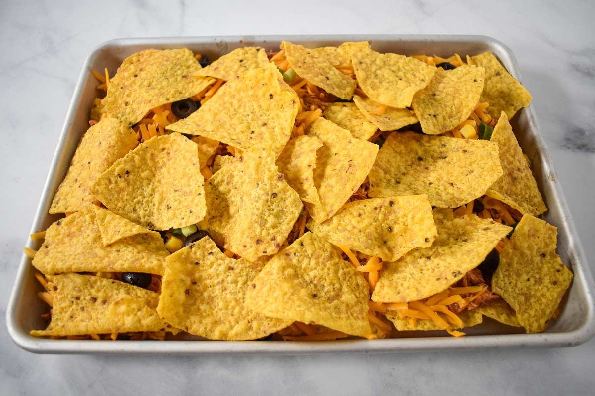Another layer of chips covering the ingredients in the sheet pan.