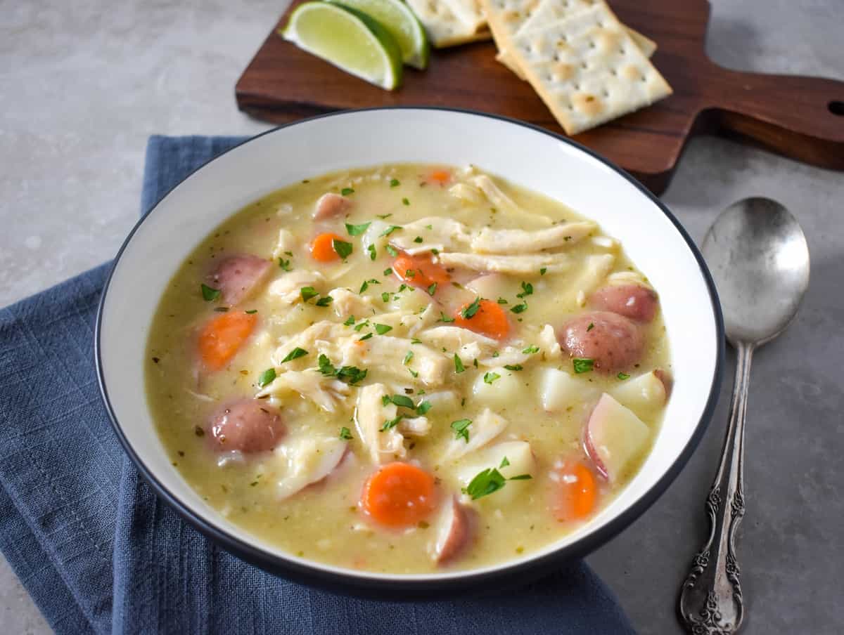 The finished stew garnished with chopped parsley, served with lime wedges and saltine crackers.