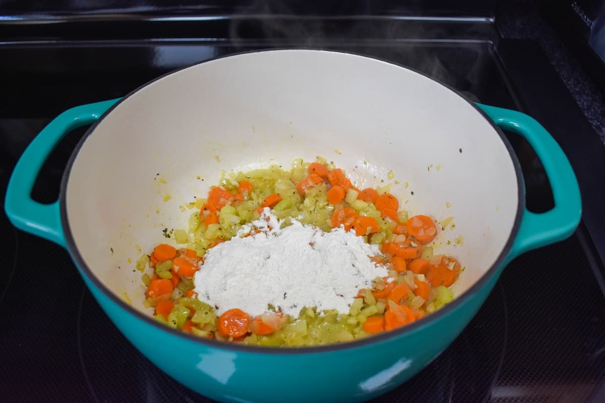 Flour added to the ingredients in the pot.