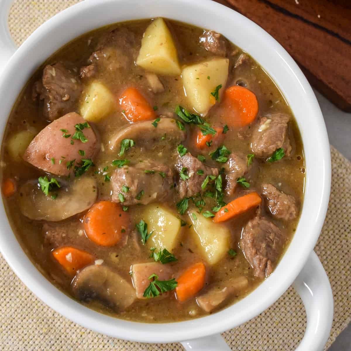 A close-up of the beef stew served in a white bowl.