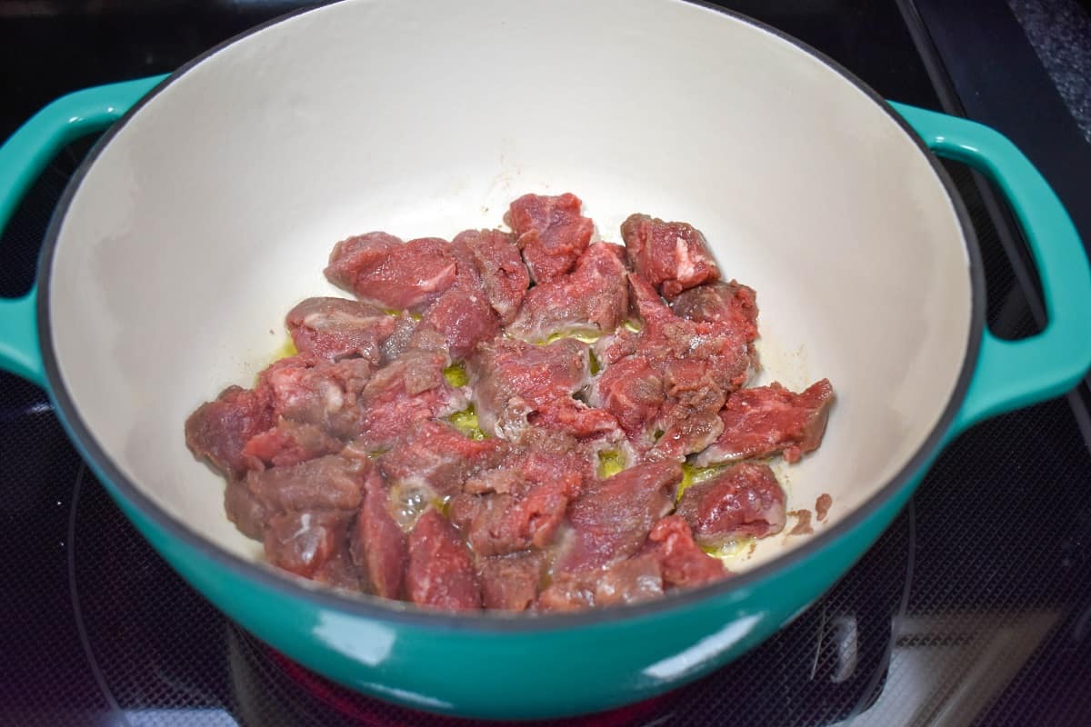 Beef pieces browning in a large pot.