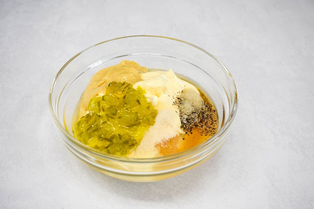 The condiments for the dressing in a glass bowl before they are stirred. 