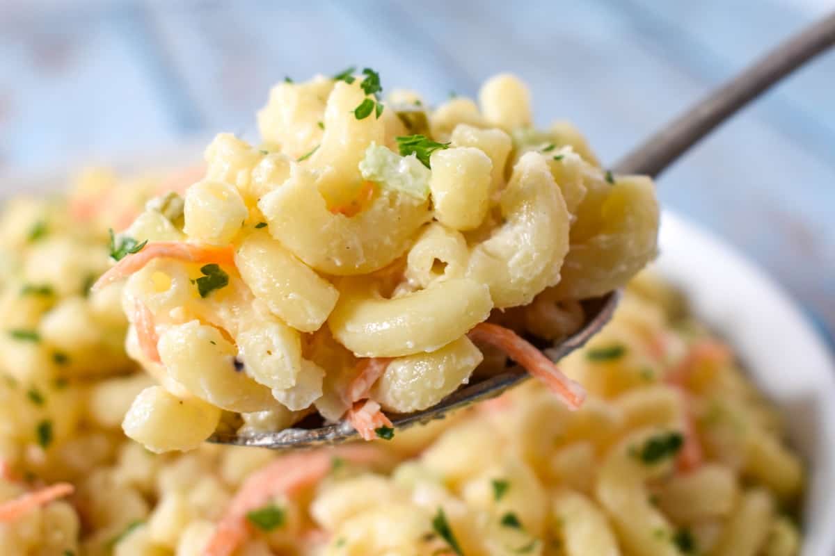 A spoonful of the finished macaroni lifted up over the bowl.