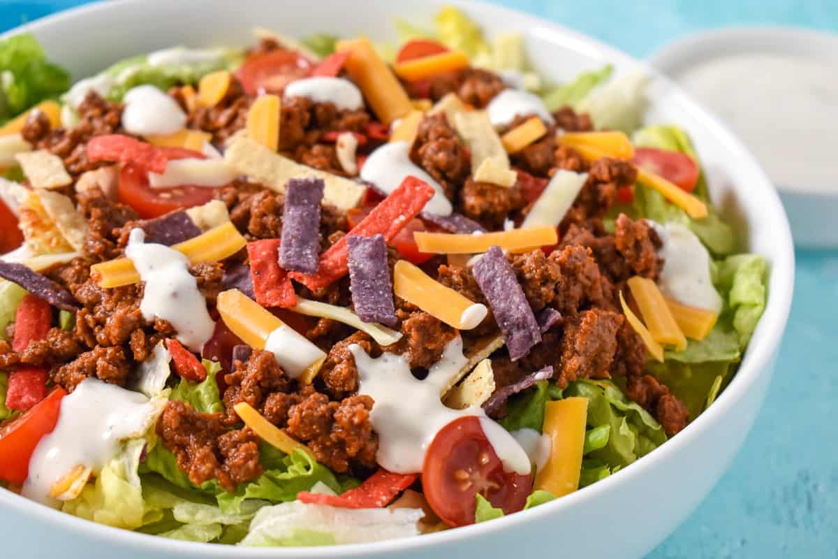 A close up of the taco salad served in a white bowl.