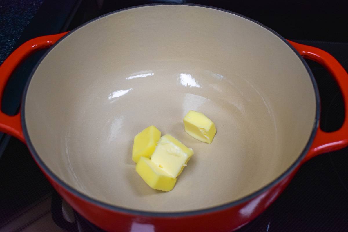 Pats of butter in a large, red pot.