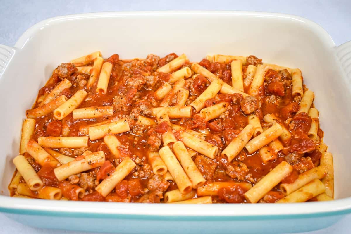 Cook ziti combined with the sausage pasta sauce in a large baking dish.