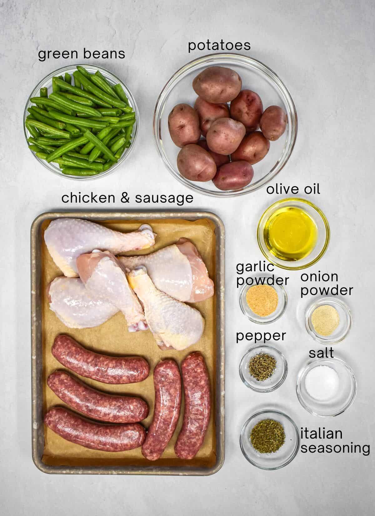 The ingredients for the dish arranged in glass bowls on a white table with each labeled in small, black letters.