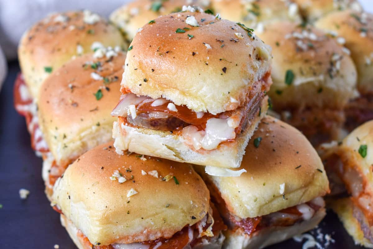 The pepperoni sausage pizza sliders with one stacked on two others.