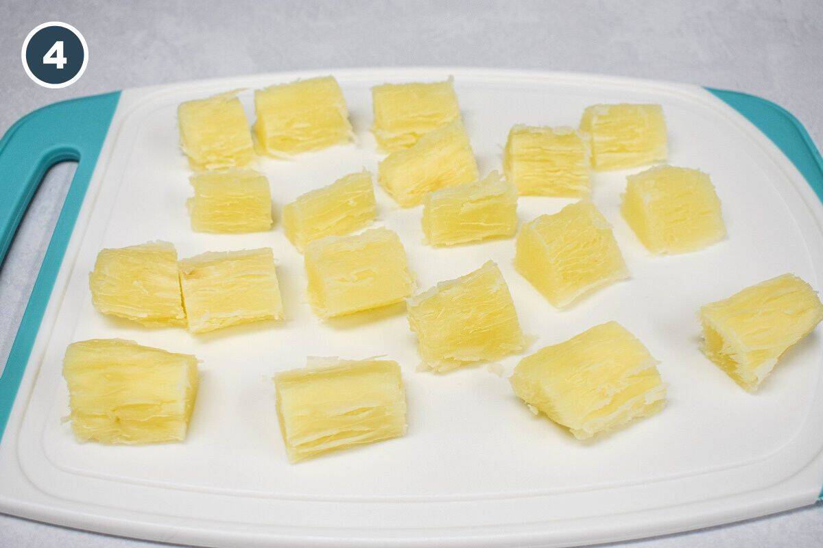 Tender yuca cut into bite-sized pieces on a cutting board.