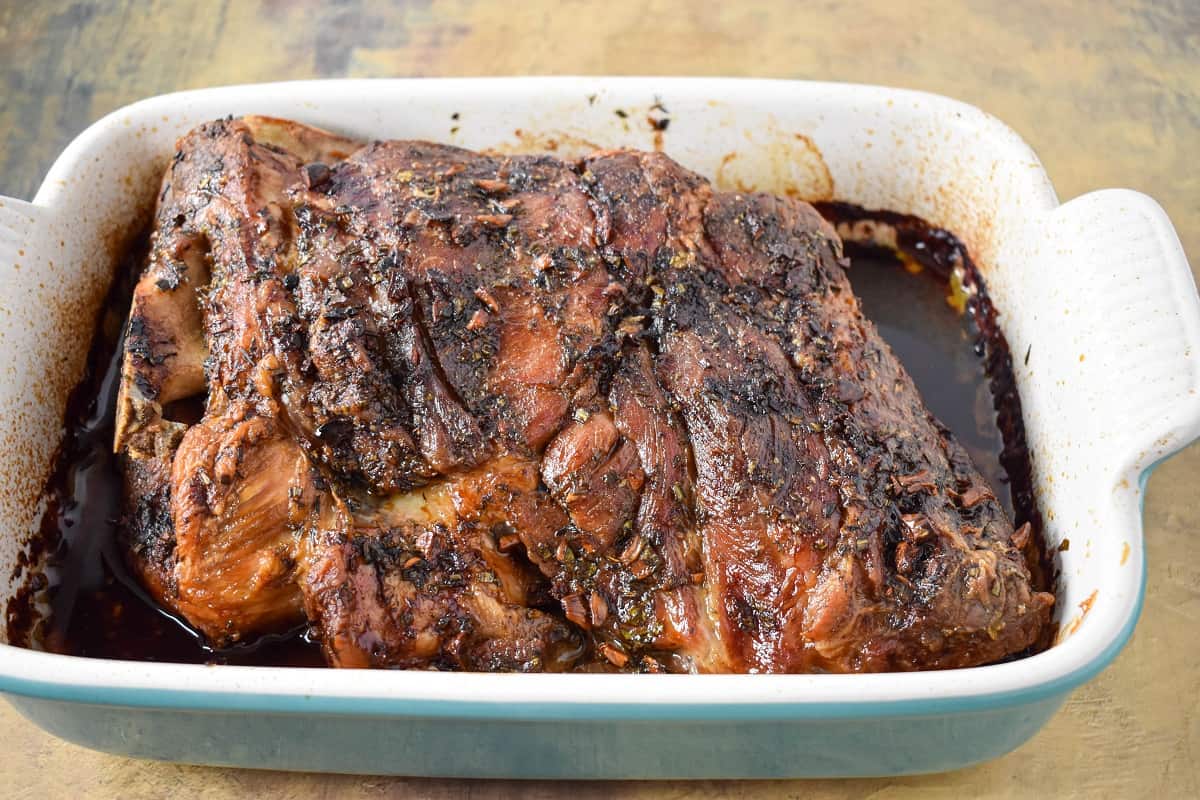 The cooked pork butt in a large baking dish.