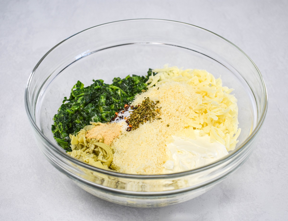 The ingredients for the filling in a glass bowl set on a white table.