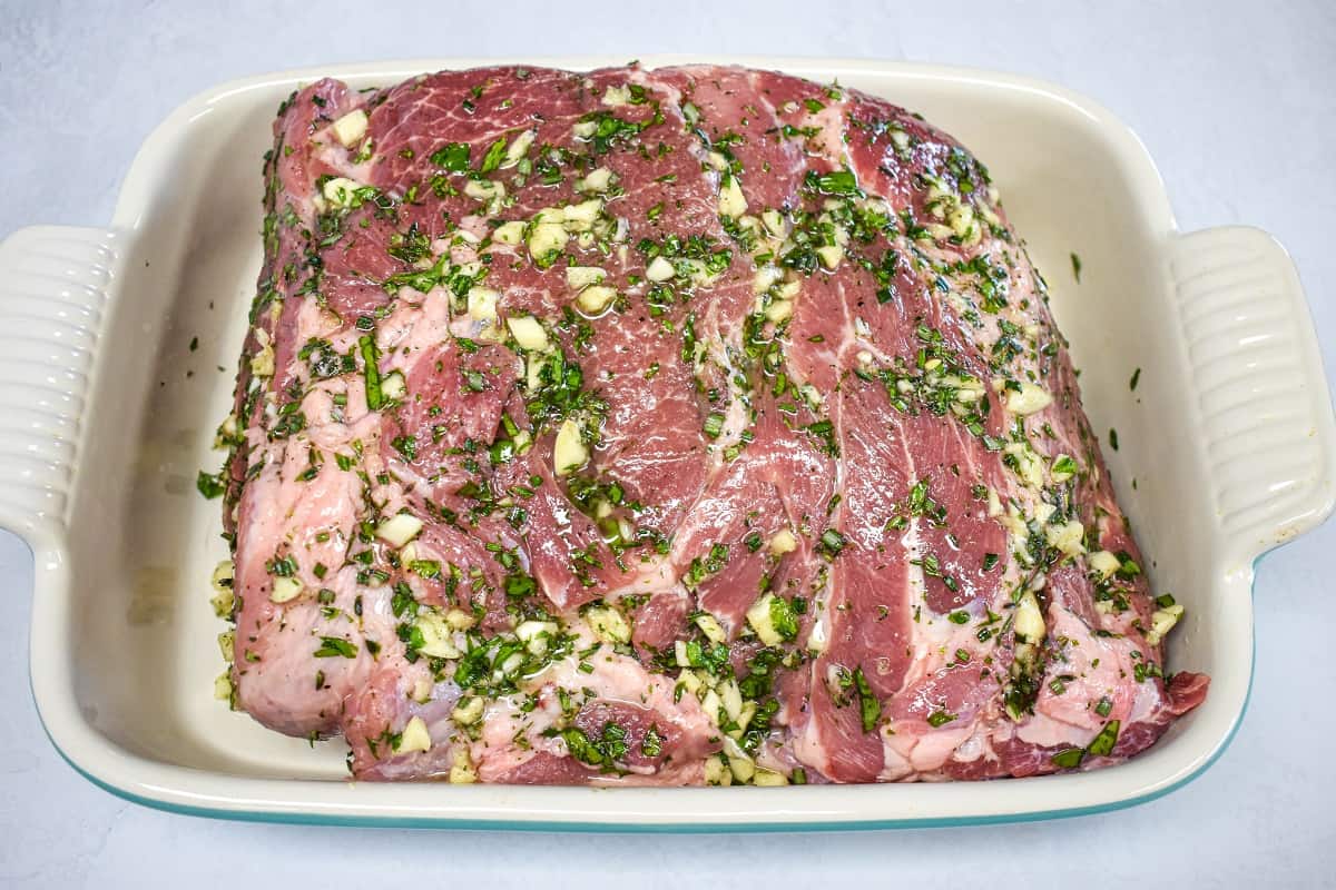 The prepared pork butt in a large baking dish prior to cooking.