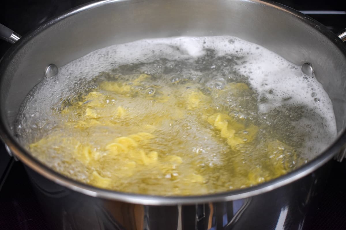 Egg noodles boiling in a large pot.