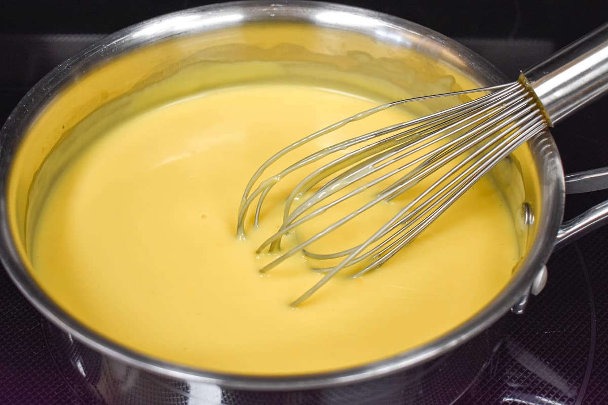 The prepared sauce in a saucepan with a whisk to the right side.