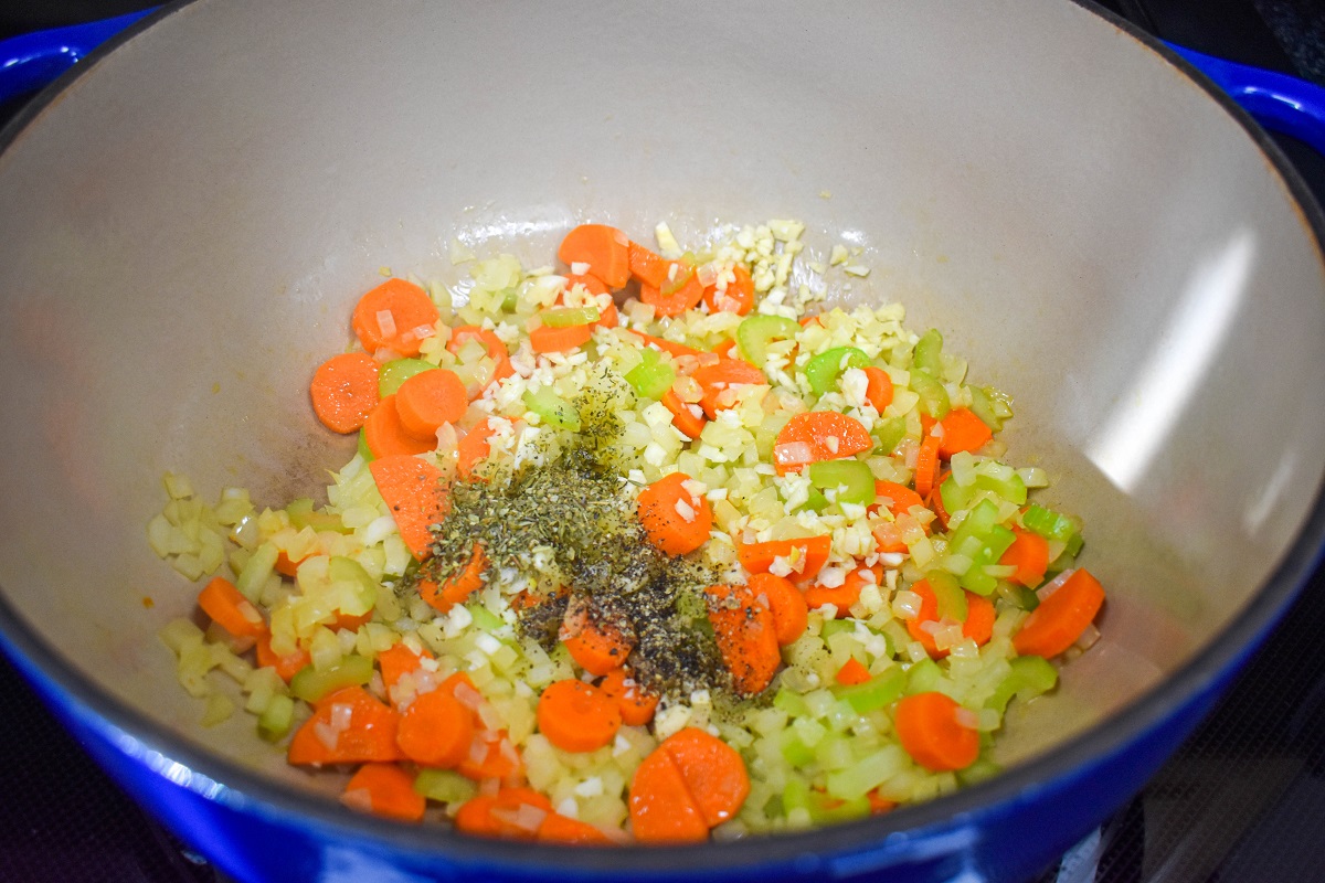 Minced garlic and seasoning added to the sautéed carrots, celery, and onions in the pot.