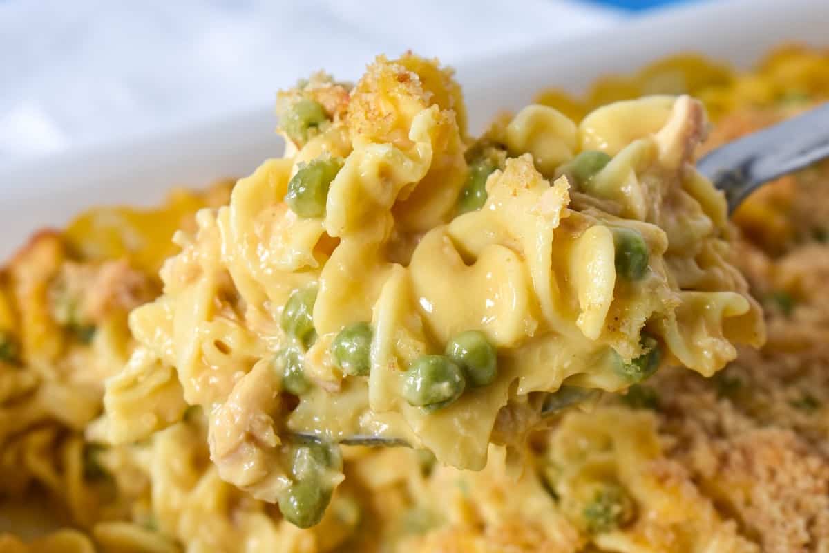 The tuna noodle casserole being served with a large spoon.