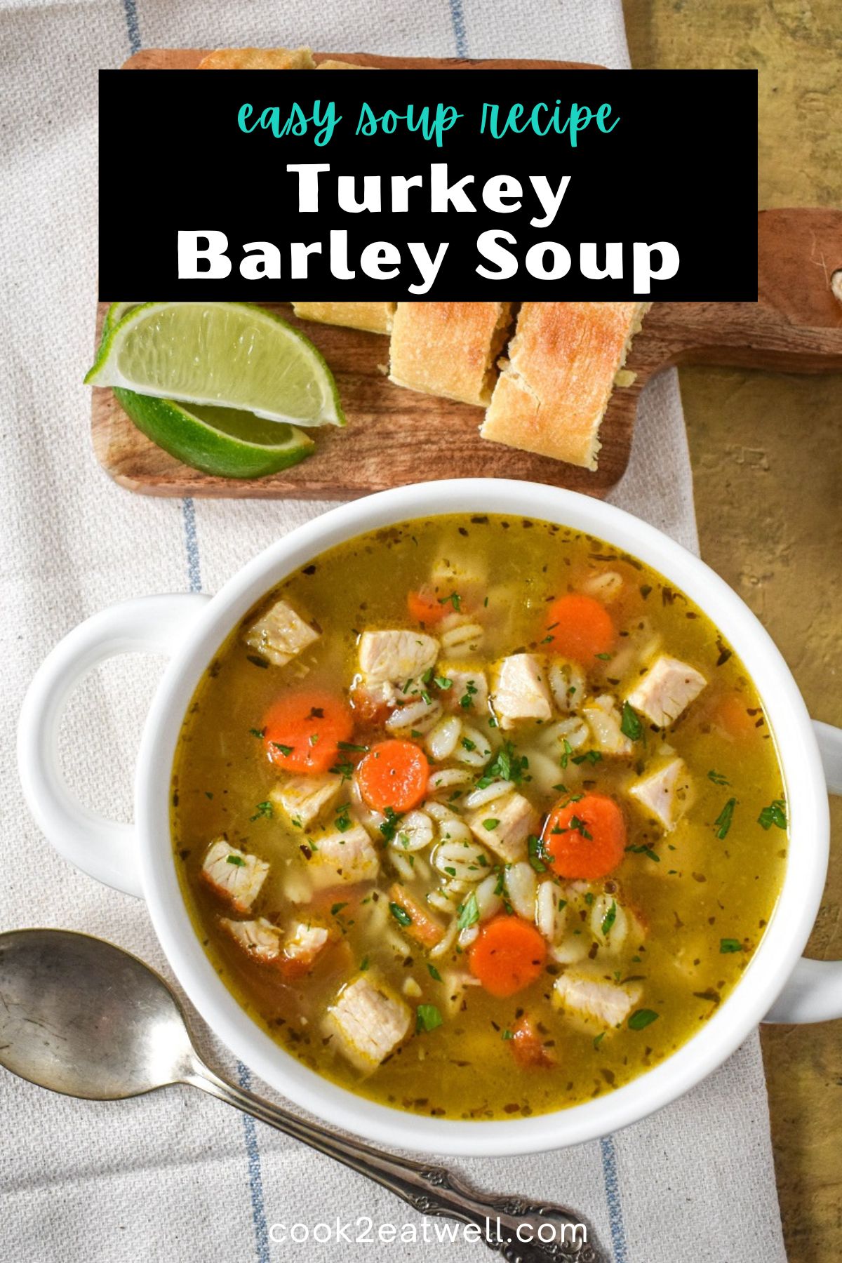 The finished turkey barley soup, garnished with chopped parsley, served in a white bowl set on a linen with sliced bread and lime wedges in the background and a black graphic with the title in white letters on top.